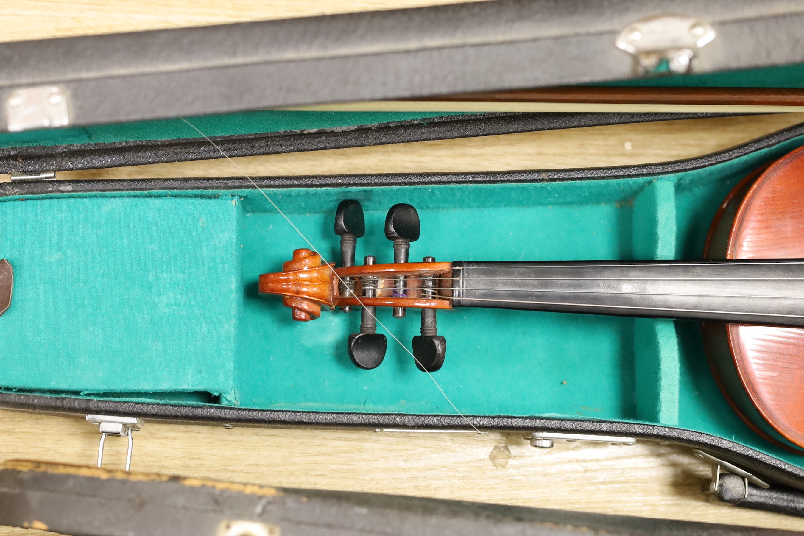 Two cased violins, one bow